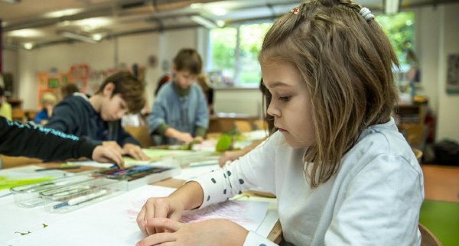 Dívka v montessori třídě kreslící na papír